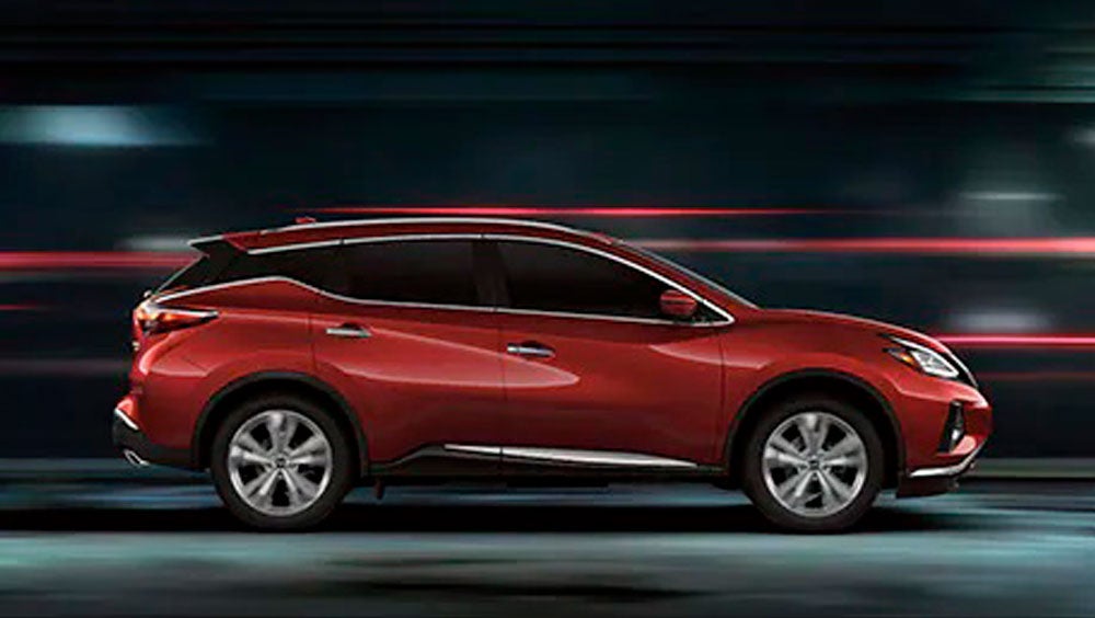 2023 Nissan Murano shown in profile driving down a street at night illustrating performance. | Grainger Nissan of Beaufort in Beaufort SC